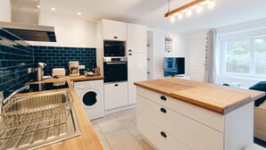 Una cocina moderna con lavadora, horno y microondas.