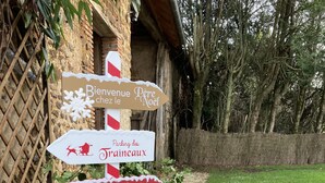 A directional signpost with multiple arrows pointing to various destinations such as "Bienvenue chez le Père Noël" and "Parking des traîneaux". - Gîte en Sancerrois (Menetou-Râtel)