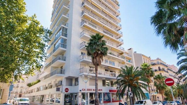 A multi-story hotel with balconies, palm trees, and a 'Galerie Marin' sign. - Appartement Gimelli – Welkeys (Toulon)