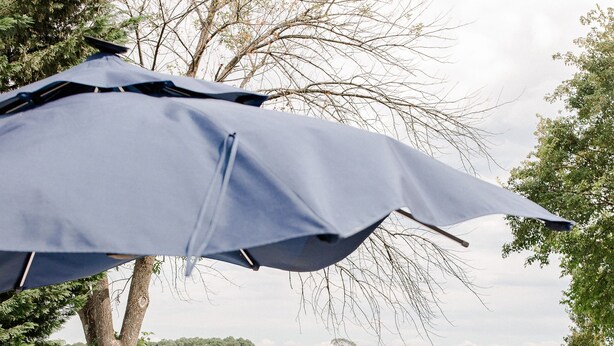 Een terras met rieten meubilair, een vuurplaats van steen en uitzicht op een meer.