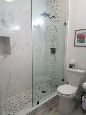 A bathroom with a glass-enclosed shower, a toilet, and a framed picture on the wall. - Classy Modern with Rustic Charm walk - 5 min walk to Lake! (Lake Arrowhead)