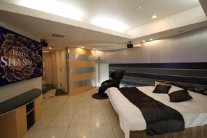 A hotel room with a bed, a massage chair, a TV, and a wall-mounted artwork. - Hotel Shasha Toyonaka - Adult Only (Toyonaka)