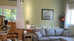 Una sala de estar acogedora con un sofá, una mesa de centro y un comedor con una mesa y sillas.
