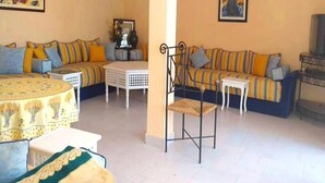 Una sala de estar con un sofá, una mesa de comedor y una silla.
