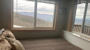 A bedroom with a large window offering a mountain view. - 10-202 (Banner Elk)