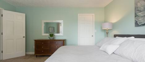 Un dormitorio con cama, cómoda y ventilador de techo.