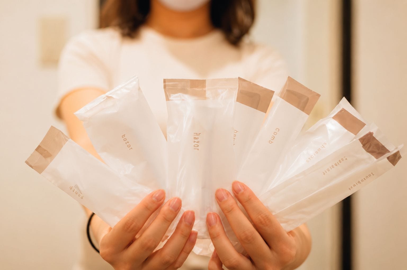 A person holding several transparent bags with text on them.