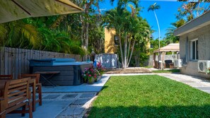 A backyard with a barbecue area, a wooden deck, and a small garden.