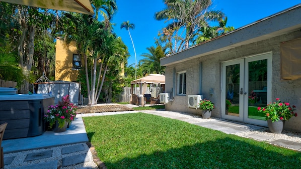 A backyard with a patio, outdoor seating, and a pool.