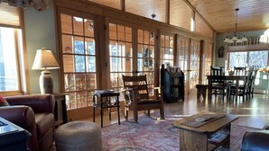 A spacious living room with large windows, a fireplace, and a cozy seating area.