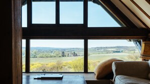Una habitación con un amplio ventanal que ofrece vistas a un paisaje campestre.