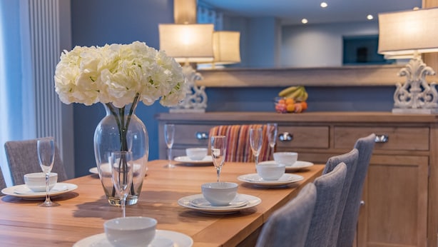 A dining table set with white plates, bowls, and a vase of white flowers. - Customs House by Bloom Stays,  Large house for family groups of up to 20 (Faversham)