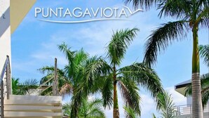 A modern outdoor area with a white staircase, palm trees, and lush greenery. - ☺ PUNTAGAVIOTA ☺ HUATULCO ☺ ARROCITO BEACH ☺ (Santa Cruz Huatulco)