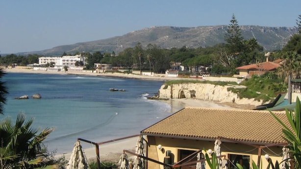 A coastal view with a beach, a building with a tiled roof, and a mountainous background. - Villa by the sea - in full relaxation - Air conditioned - Wi-fi (Fontane Bianche)