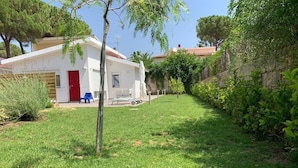 A white building with a red door, a small garden, and a clear sky. - Villa by the sea - in full relaxation - Air conditioned - Wi-fi (Fontane Bianche)