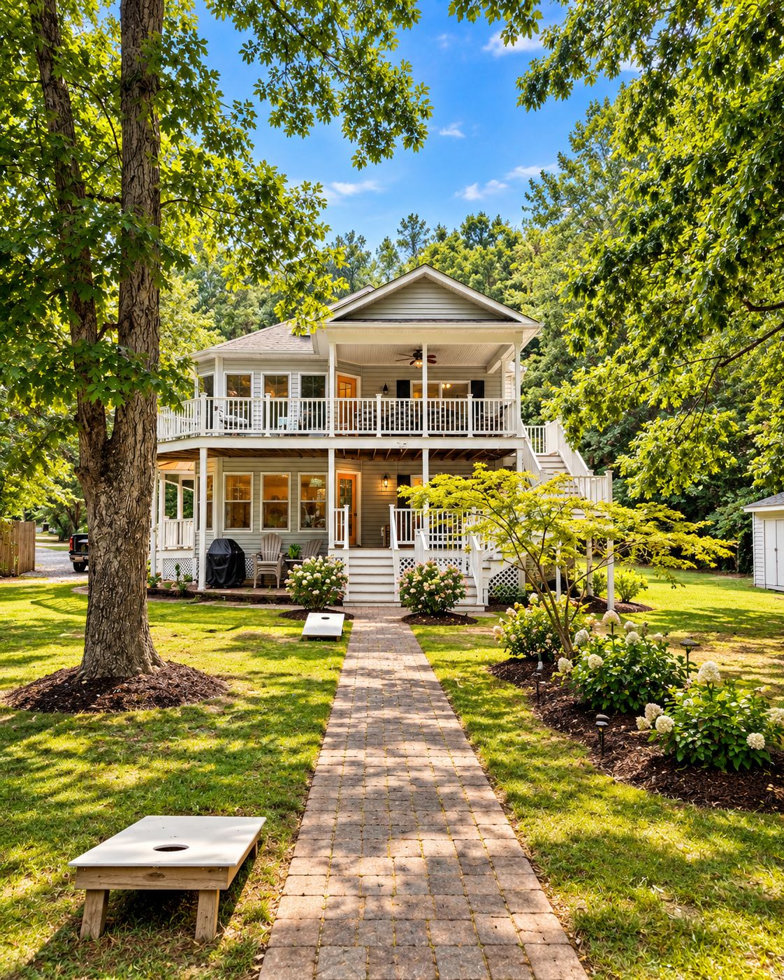 A two-story house with a front porch, a covered deck, and a pathway leading to the entrance.