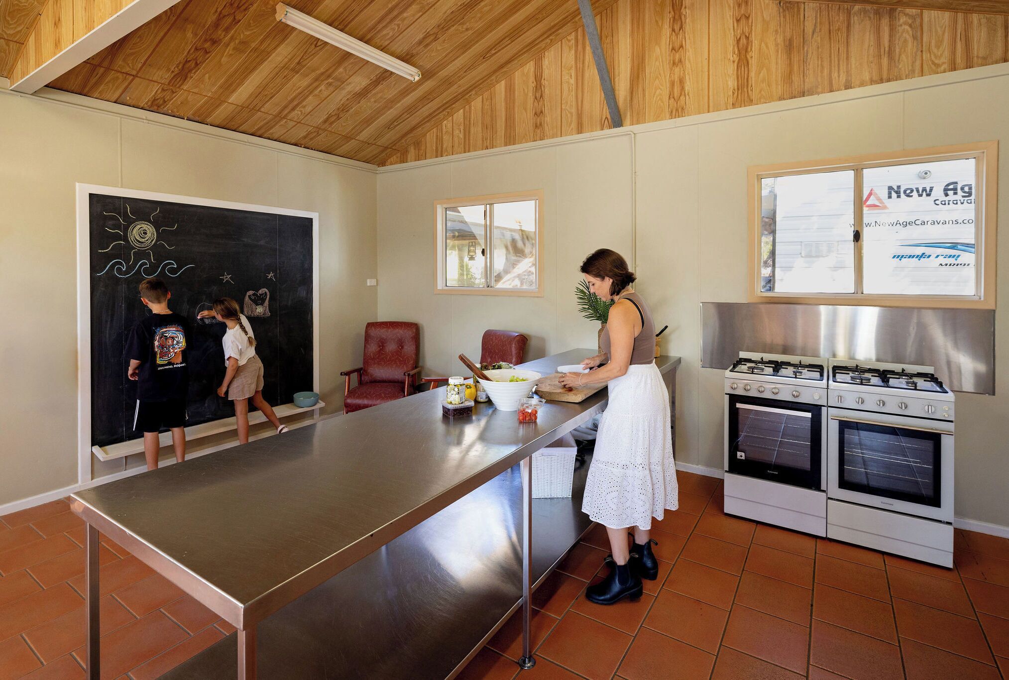 Une cuisine avec un tableau noir, une cuisinière et une fenêtre.