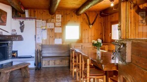 A rustic wooden interior with a stone fireplace, wooden bench, and a dining table with chairs. - Rustico Catcüc by Interhome (Malvaglia)