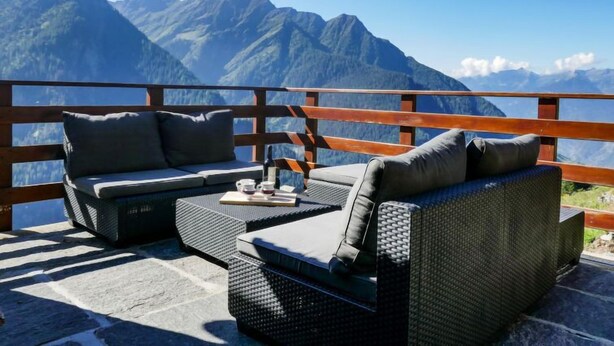 A balcony with wicker furniture and a view of mountains. - Rustico Catcüc by Interhome (Malvaglia)