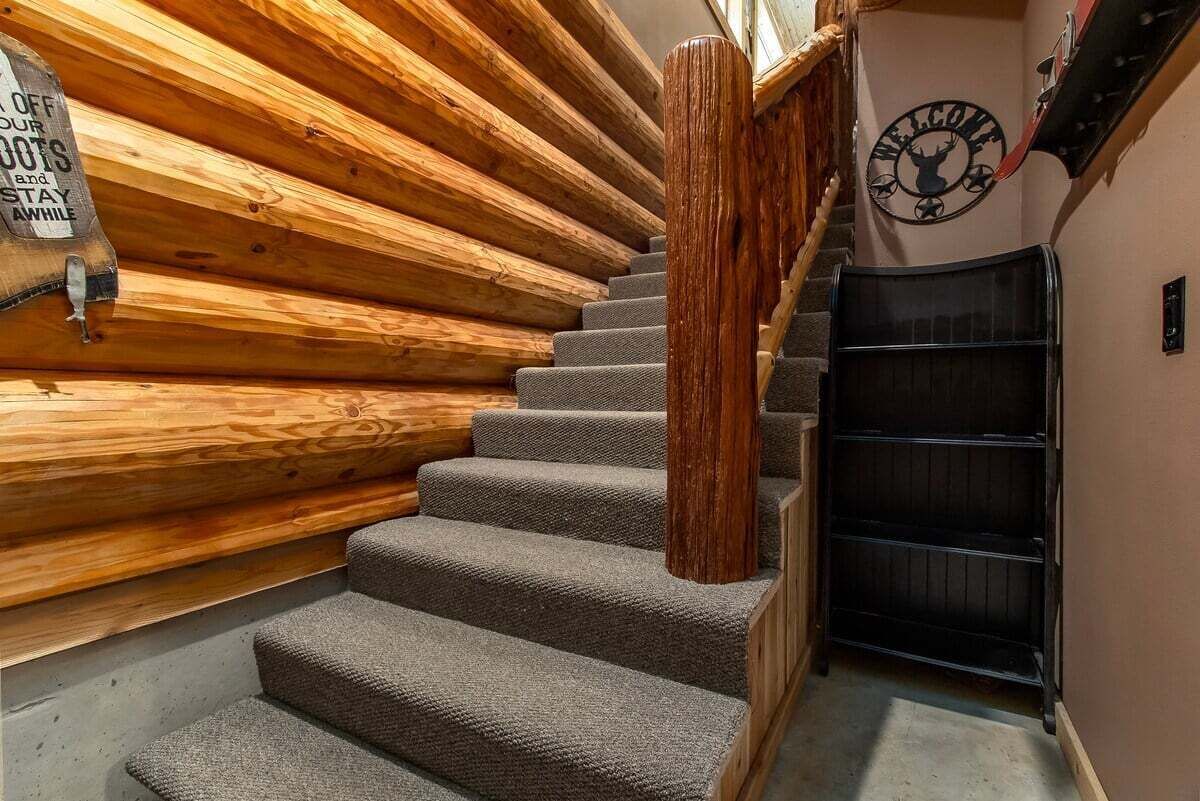 Eine Treppe mit Holzbeschlägen und einem Teppichgeländer, die zu einer Tür mit der Aufschrift 'WELCOME' führt.