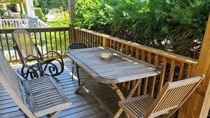 Une terrasse en bois avec une table et deux chaises.