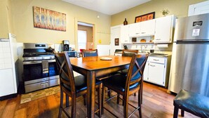 Une cuisine compacte comprenant une table à manger, des chaises, un réfrigérateur et un four à micro-ondes.