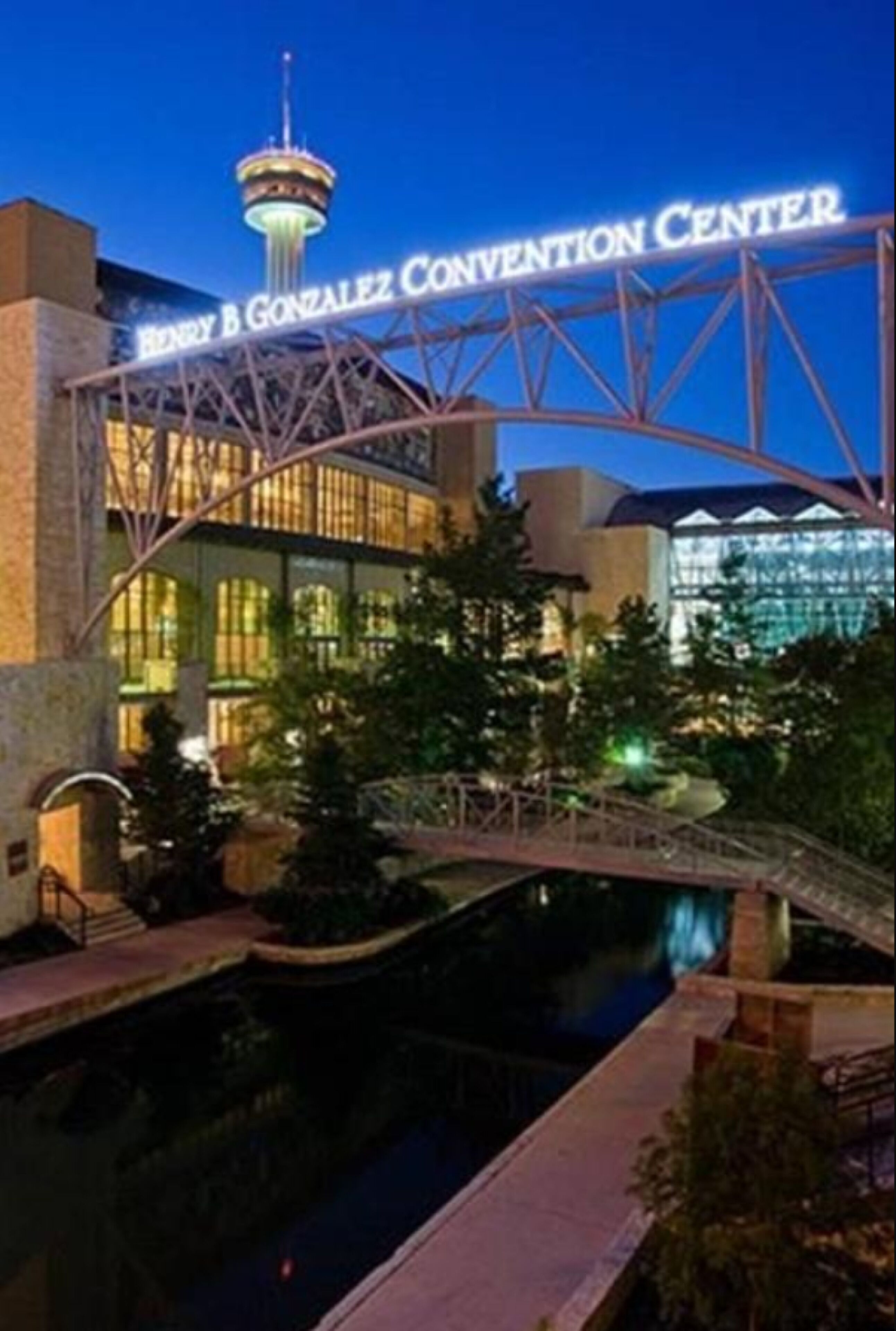 The Henry B. Gonzalez Convention Center with a prominent tower and a bridge over a water feature.