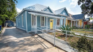 A two-story house with a blue exterior and a yellow door. - Classic 1br/1ba Charming Apt w/ Modern Upgrades (San Antonio)