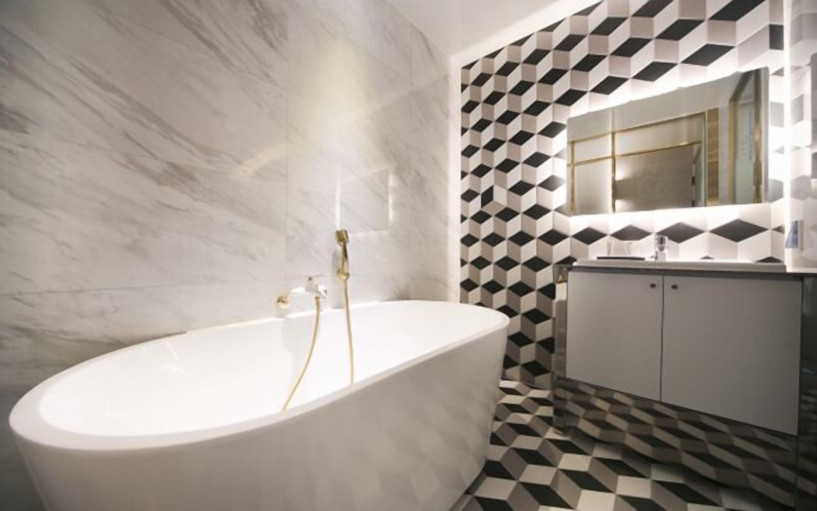 A bathroom with a freestanding bathtub, a white vanity with a mirror, and a black and white geometric patterned wall.