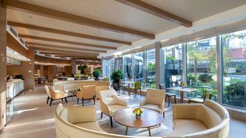 A spacious lobby with modern furniture, large windows, and a view of the outside.