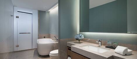 A modern bathroom with a large mirror, a bathtub, and a sink.