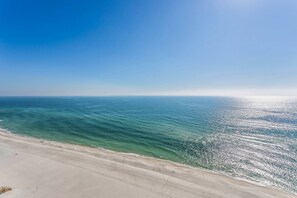 A beach with clear blue water and a sandy shore.
