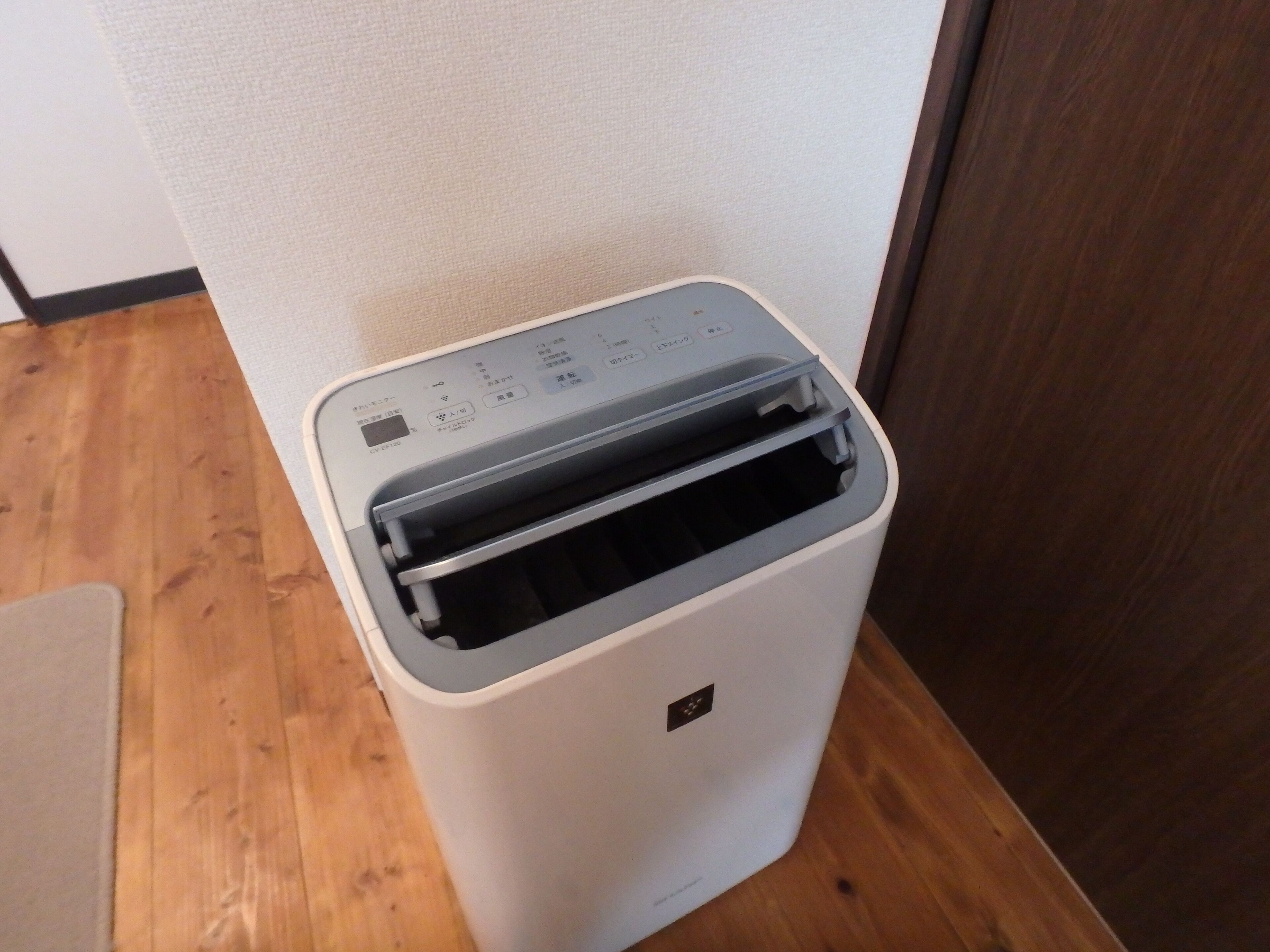 A compact, white, wall-mounted printer with a control panel and a paper output tray.
