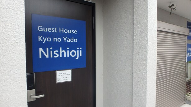 A door with a sign indicating it is the Guest House Kyo no Yado Nishioji.