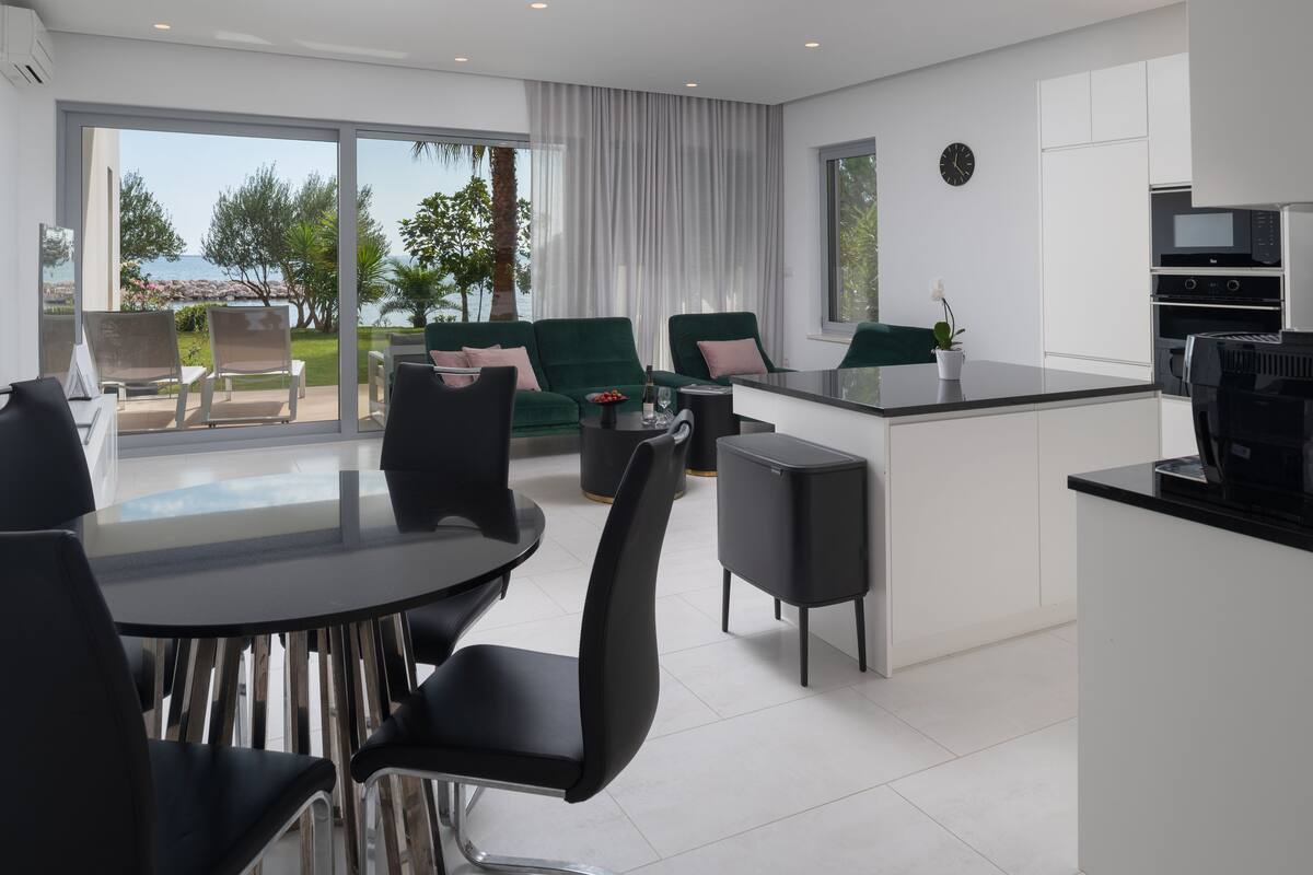 Una cocina moderna con comedor, ventanas amplias y vistas al exterior.