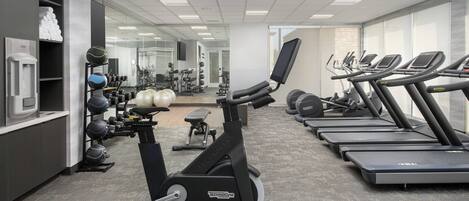 A gym with treadmills, an elliptical, and various weights.