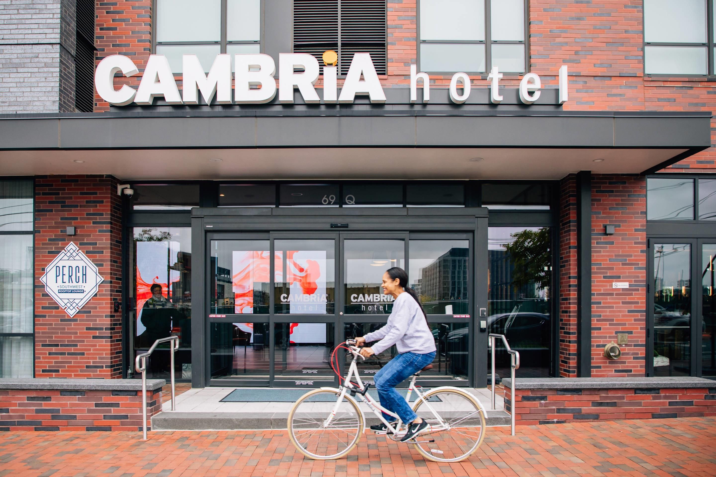 Entrada de um hotel com uma placa indicando 'CAMBRIA hotel'.