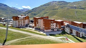 Un moderno hotel con diversi edifici, una seggiovia e le montagne sullo sfondo.