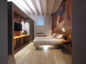 A bedroom with a bed, a TV, a desk, and a painting on the wall. - Leoni di Collalto Palace (Treviso)