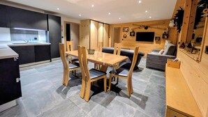 Eine moderne Küche mit integriertem Backofen und einer Essecke mit Holztisch und Stühlen.