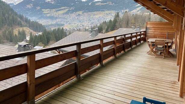 Eine Holzterrasse mit Blick auf eine Berglandschaft.