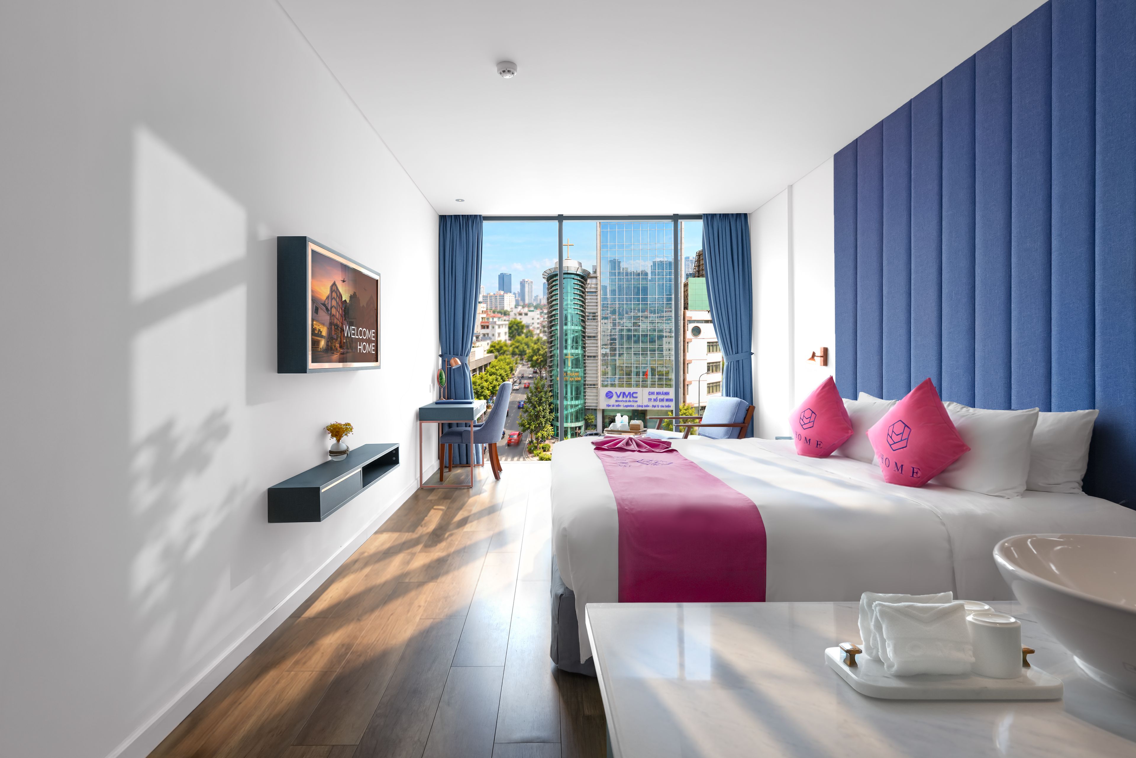 Una habitación de hotel moderna con una cama grande, un escritorio y vistas a la ciudad.