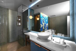 A modern bathroom with a large mirror, a white sink, and a glass shower enclosure. - HOME Hotel (Ho Chi Minh City)