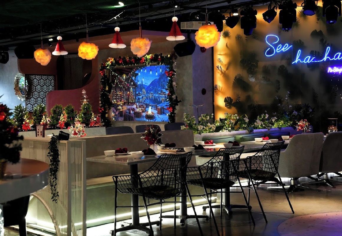 Un restaurante con decoración navideña festiva, un letrero de neón y un diseño de interiores moderno.