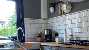 A kitchen with a wooden countertop, a coffee maker, and a stove.