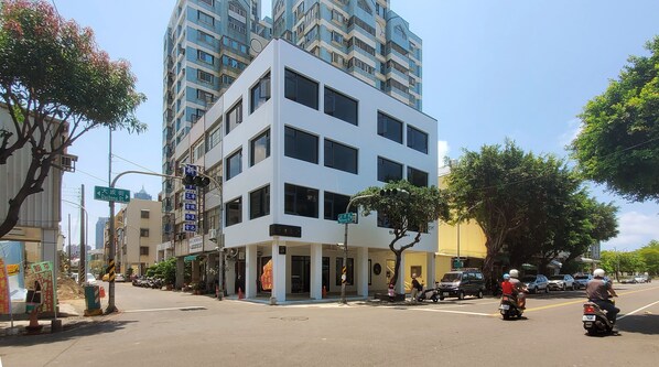 A multi-story building with a white facade, large windows, and a flat roof. - Little Inn (Kaohsiung)