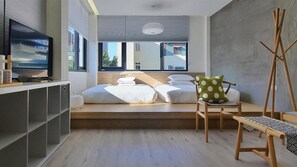 A modern bedroom with a bed, a chair, a TV, and a desk. - Little Inn (Kaohsiung)