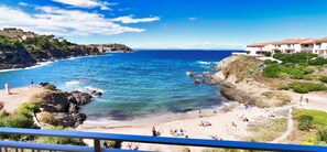 A coastal beach with rocky terrain and a clear view of the sea.