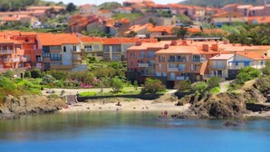 A coastal residential area with colorful buildings, a beach, and a clear view of the sea.