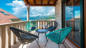 Ein Balkon mit zwei Stühlen und einem Tisch mit Blick auf eine Berglandschaft.